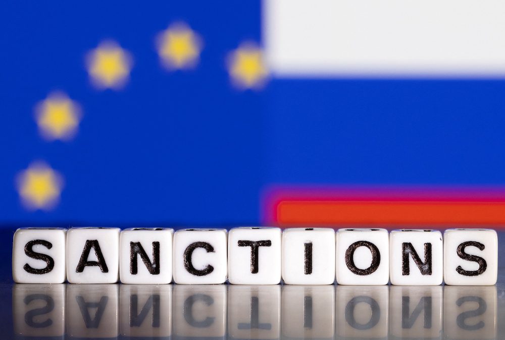 FILE PHOTO: Illustration shows letters arranged to read "Sanctions" in front of flag colors of EU and Russia