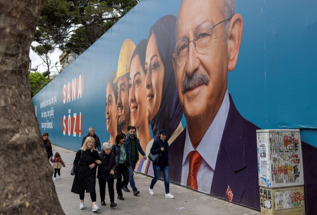 People walk past an election banner of Kemal Kilicdaroglu, presidential candidate of Turkey's main opposition alliance, ahead of the May 14 presidential and parliamentary elections, in Istanbul, Turkey May 10, 2023. REUTERS/Umit Bektas